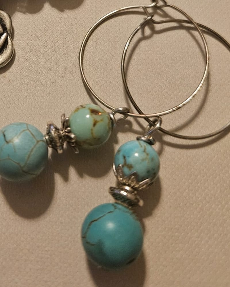 Örhängen i turkos jade med silverfärgade detaljer på ringar